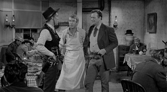 Enraged, persnickety dishwasher Stoddard is protected by Tom Donofin (John Wayne) against Liberty Valance. Marvin stands on tiptoe to look more imposing than the 6ft-4 of the two protagonists.